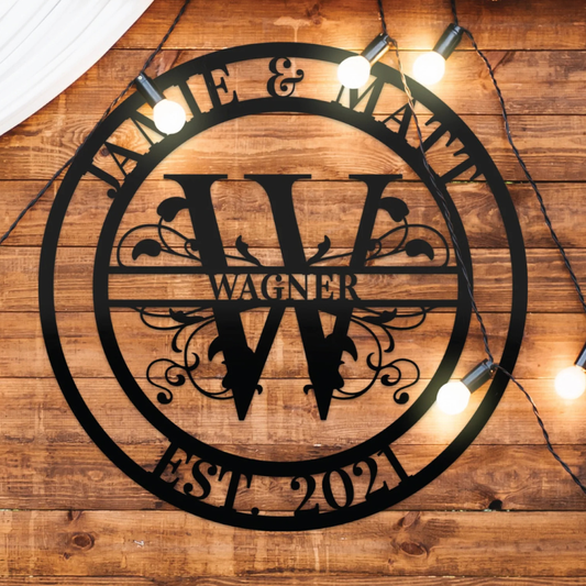 Corten-Stahl-Lebensbaum mit graviertem Namen ‚Becker 2002‘ und Eichenblatt-Muster, montiert an einer Fachwerkwand im Garten. Umgeben von einem Holztisch mit Jagdtrophäen und einer Kupferlaterne